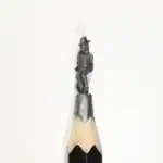 Personnage au chapeau haut-de-forme - Figurine miniature représentant un personnage élancé debout, coiffé d'un chapeau haut-de-forme, en tenue habillée avec manteau et détails vestimentaires visibles.