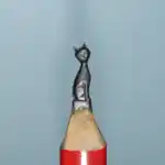 Chat élancé - Figurine miniature représentant un chat assis au corps allongé, la tête levée, avec oreilles et moustaches détaillées.