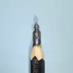 Tintin - Figurine miniature représentant Tintin en uniforme, coiffé d'un chignon, les bras le long du corps.