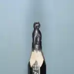 Chat égyptien assis - Figurine miniature représentant un chat assis de face, au corps compact, évoquant les statuettes félines de l'Égypte ancienne.