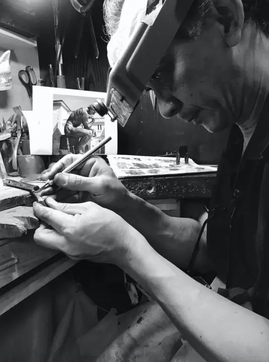 Tiao Sisaleumsack en train de tailler une mine de crayon.